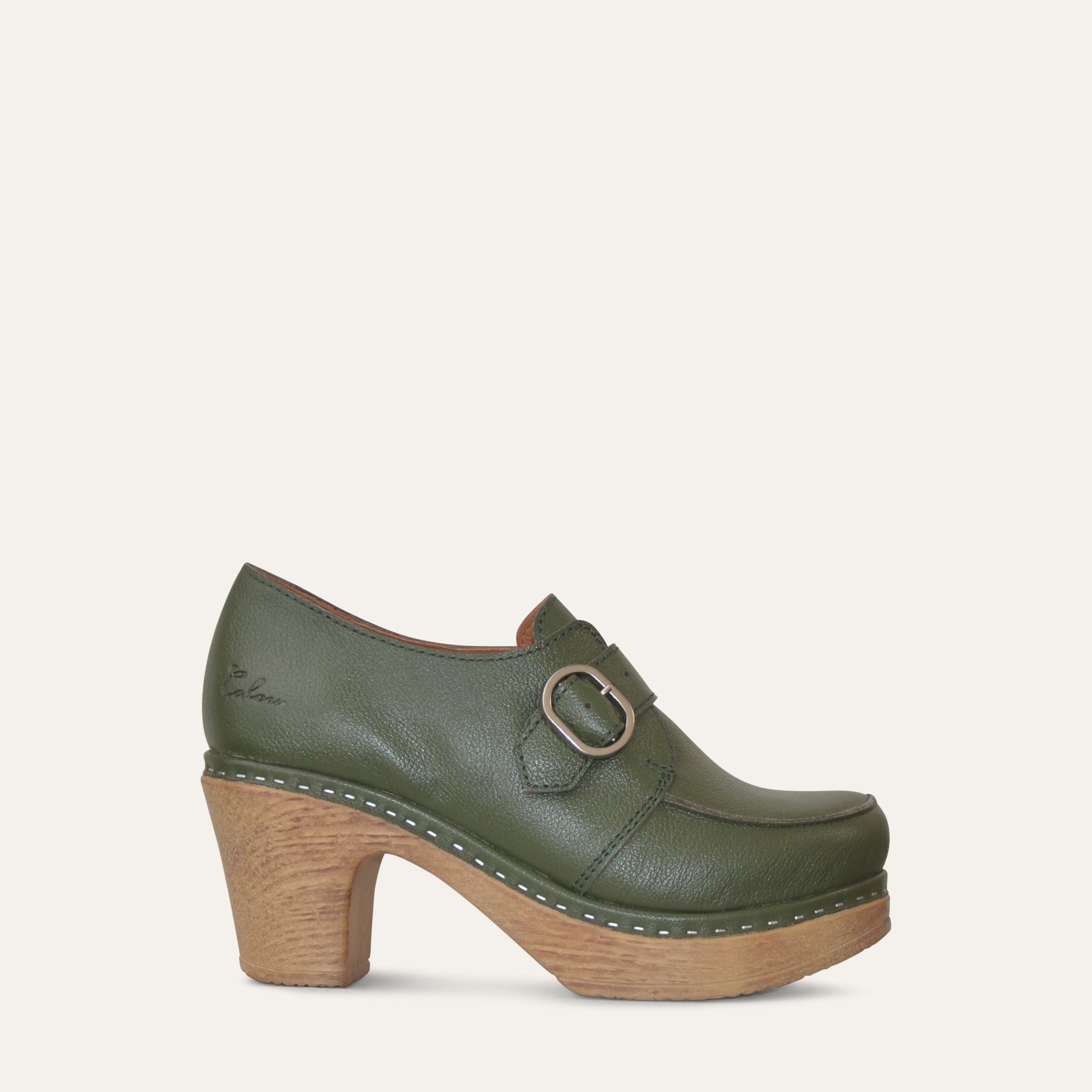 Green leather clog shoe with wood-like sole on a light gray background