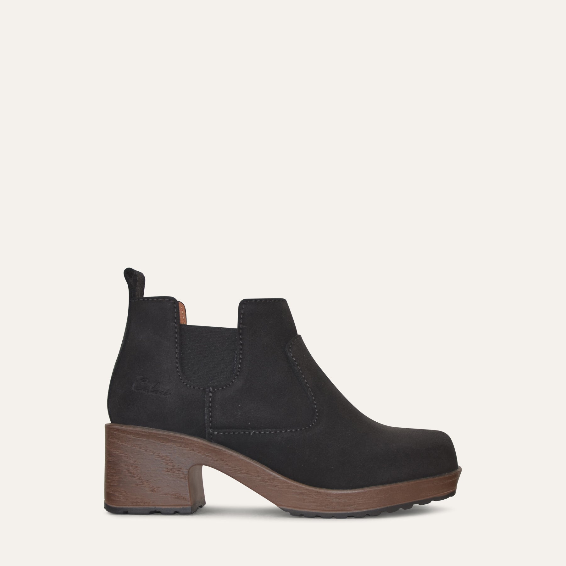 Black ankle boot with brown sole on a white background