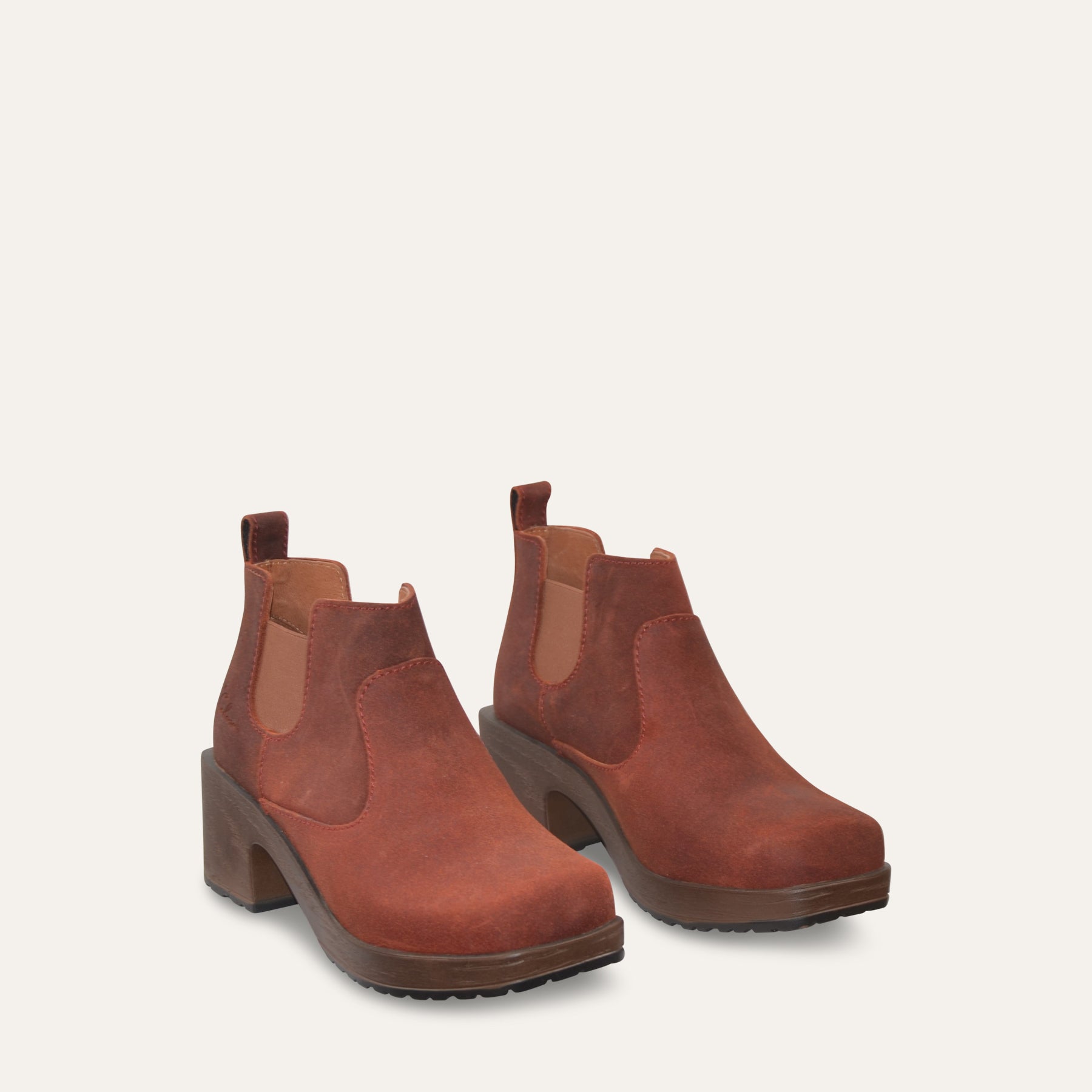 Pair of rust brown Chelsea boots on a light gray background