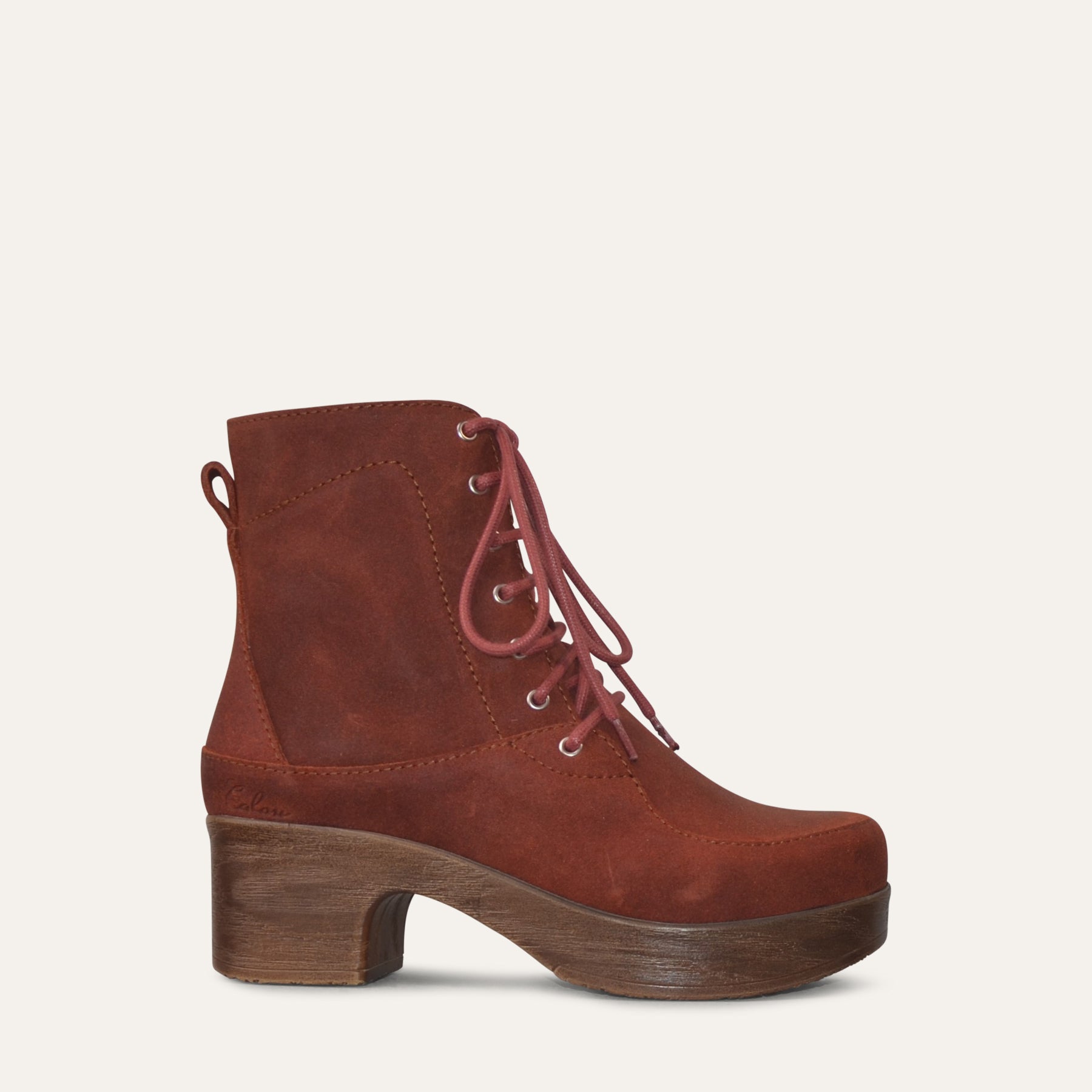 Rust Brown suede boot with a wood effect sole on a light gray background