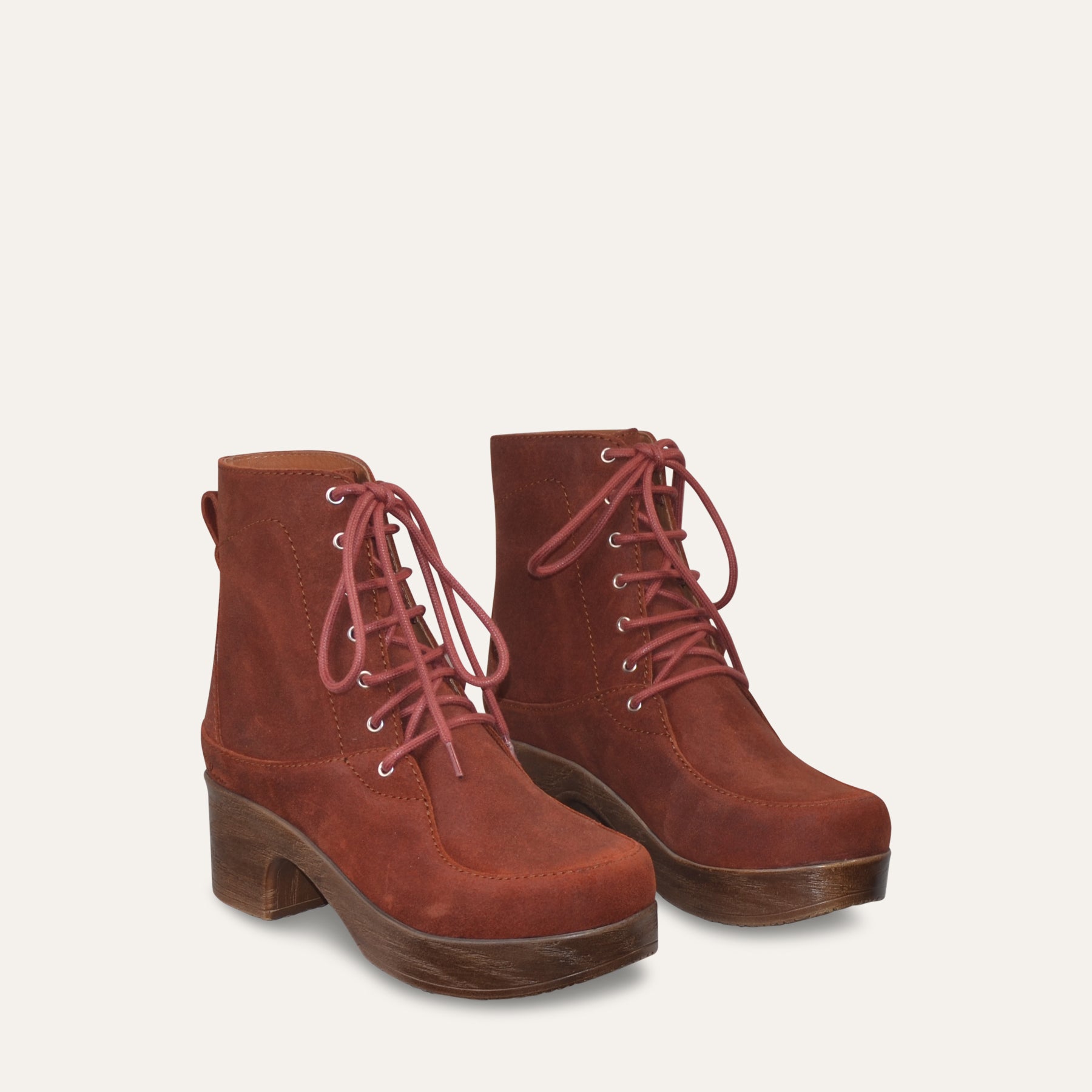 Pair of rust brown lace-up boots on a light gray background