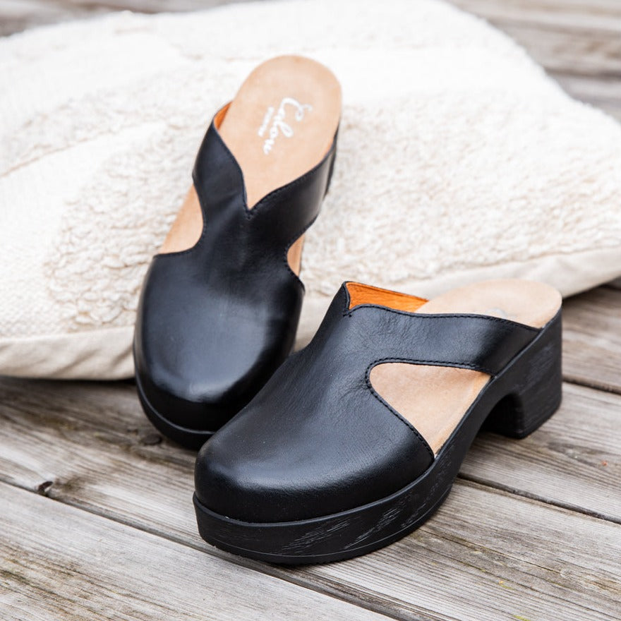 Eivor black leather clogs on wooden floor Calou Stockholm