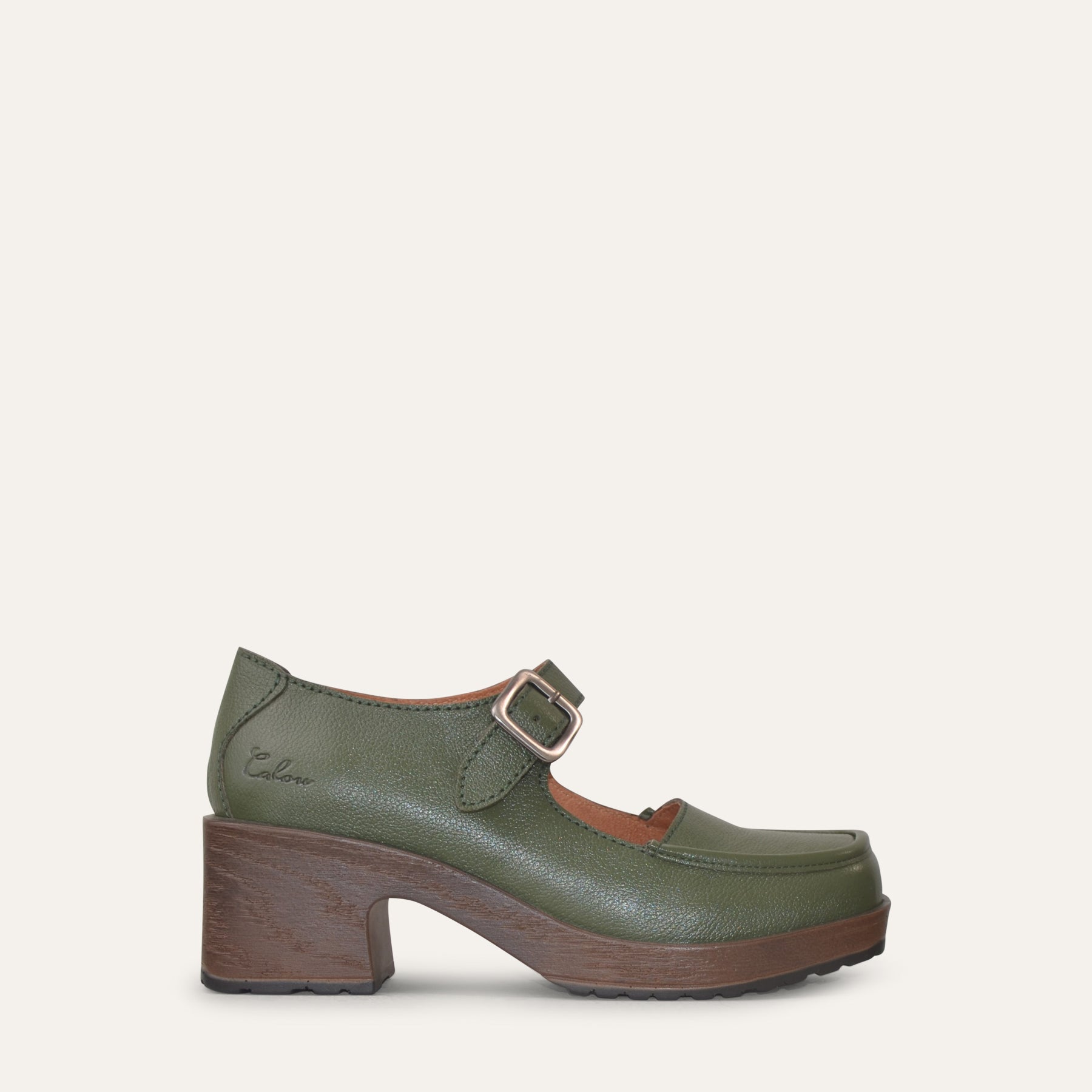 Green Mary Jane shoe with brown sole on a white background