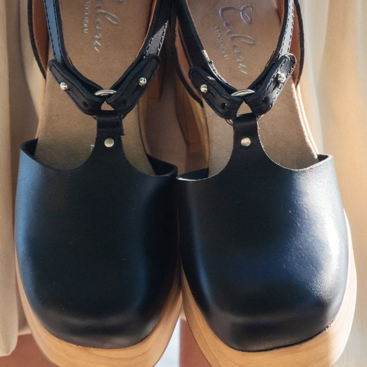 Majsan black leather clogs in hands by model calou stockholm