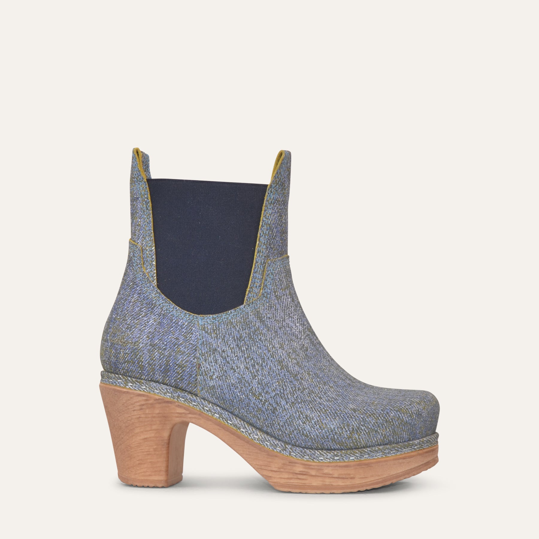 Blue denim ankle boot with wooden heel on a light gray background
