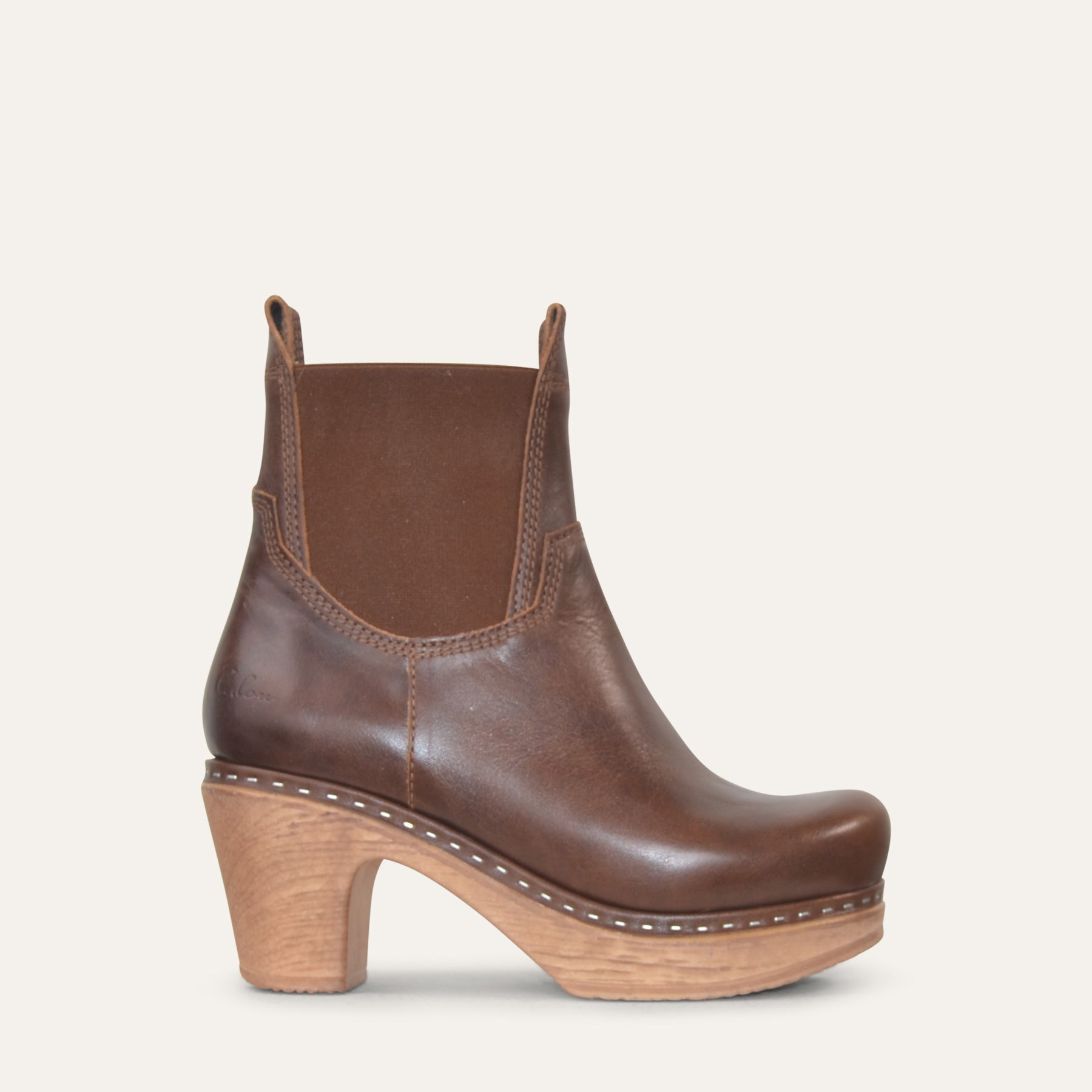 Brown leather ankle boot with wooden heel on a white background
