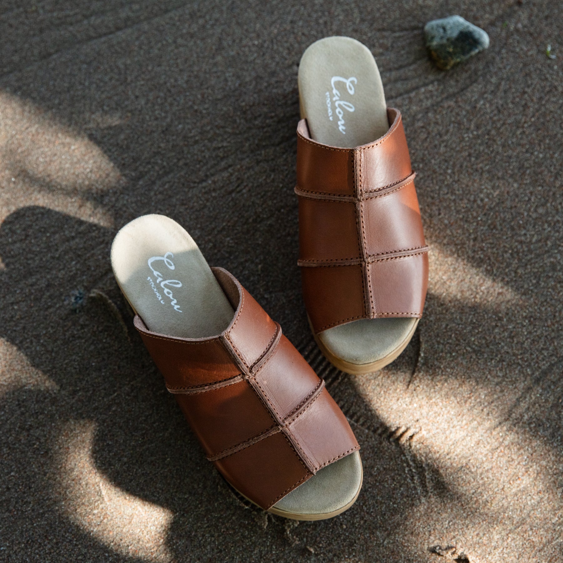 Tova brown leather clog sandals on sand Calou Stockholm