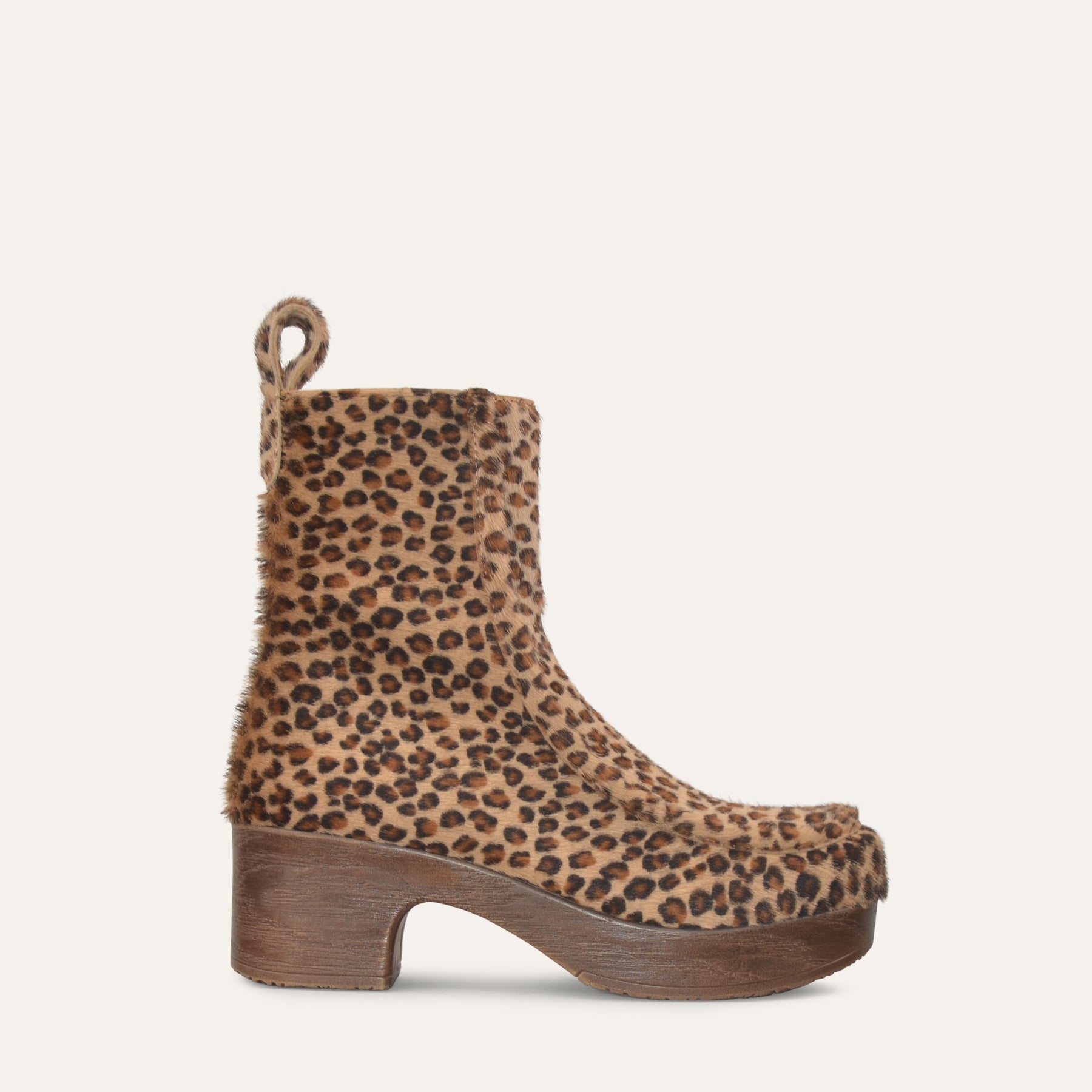 Leopard print boot with wooden sole on a light beige background