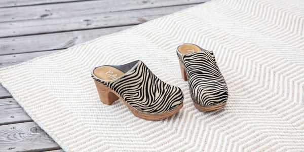 Zebra printed leather clog on soft flexible high heel base on carpet