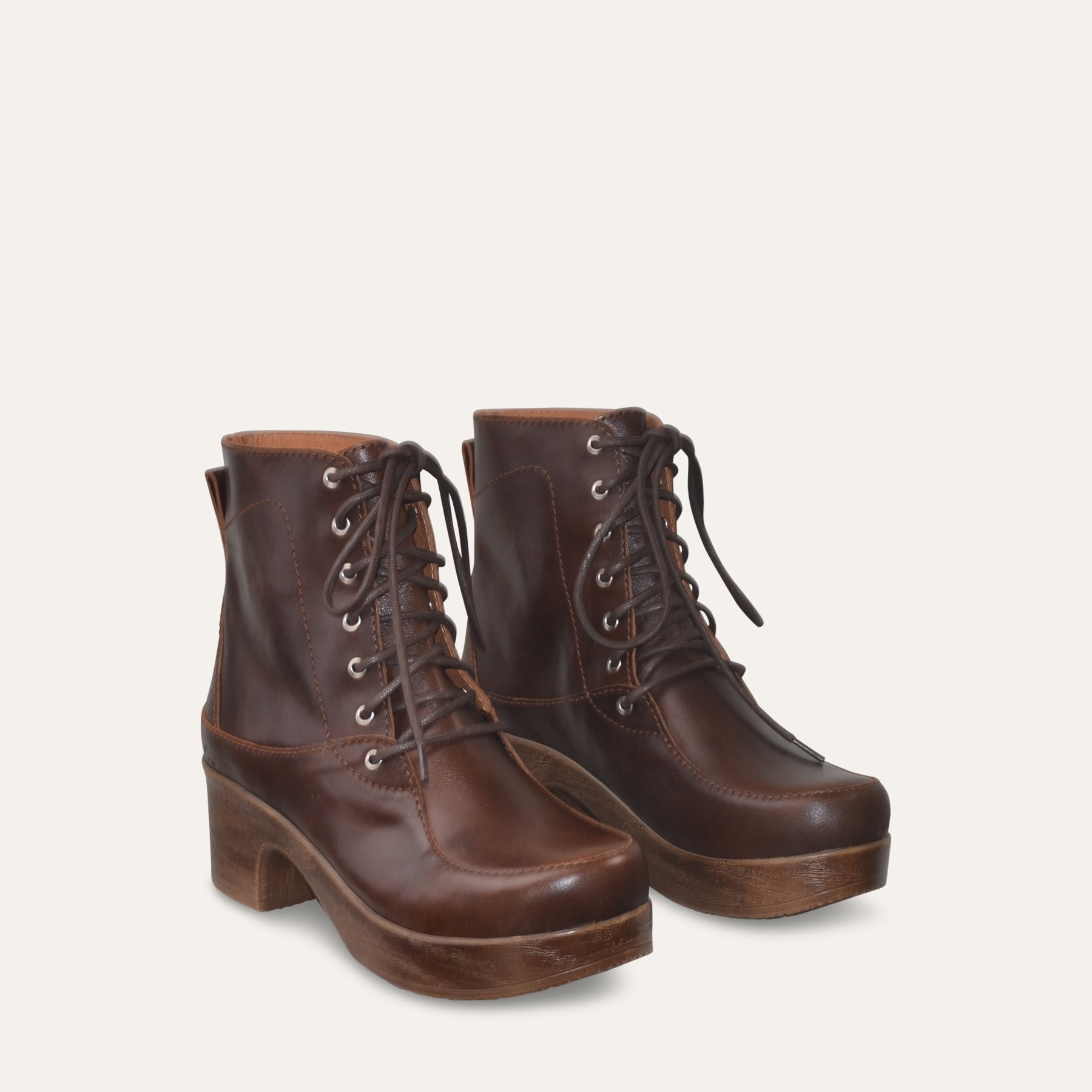 Pair of brown leather lace-up boots on a light gray background