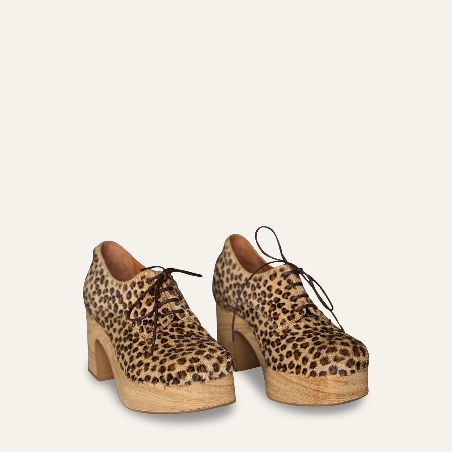 Leopard print platform shoes on a beige background