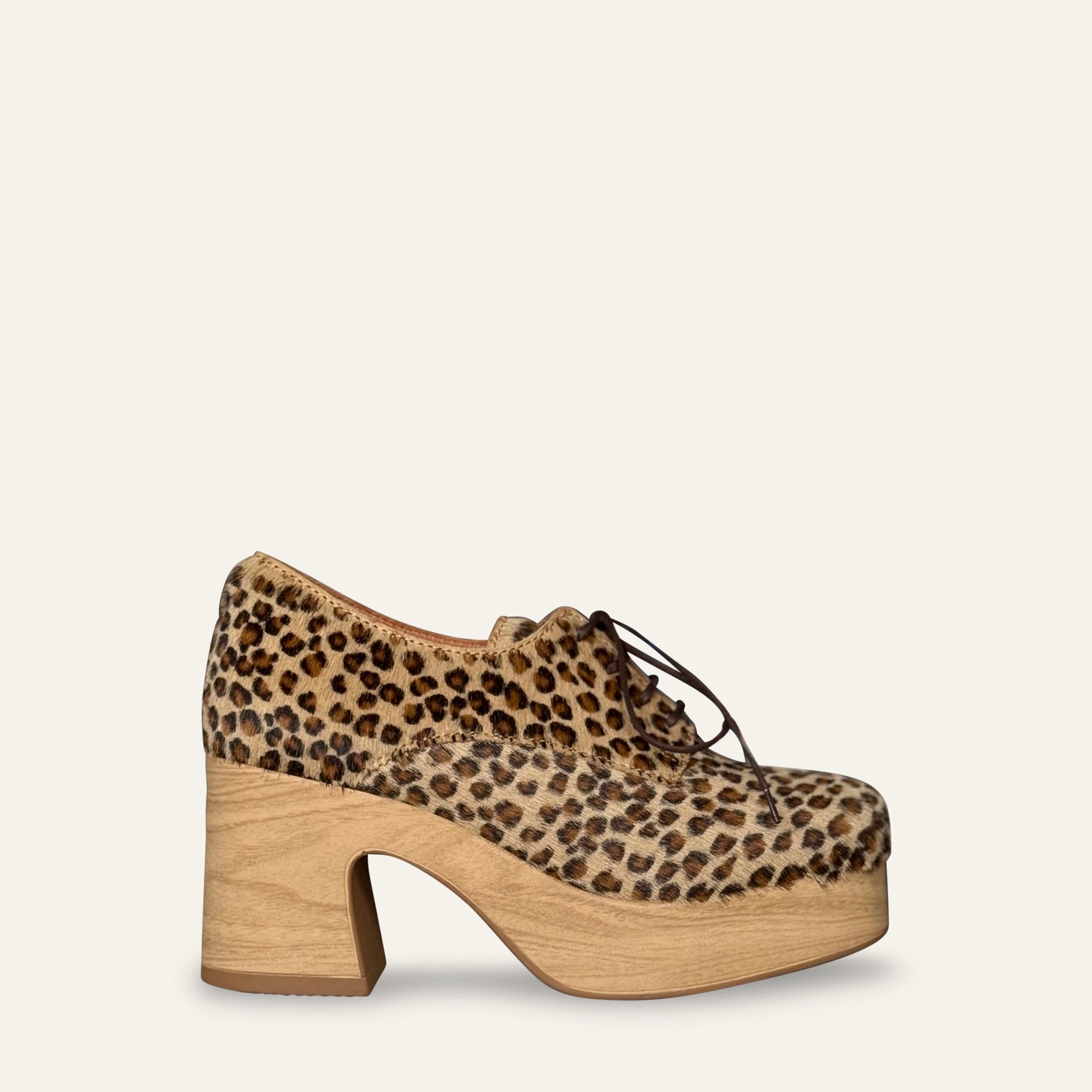 Leopard print platform shoe with wooden sole on a white background
