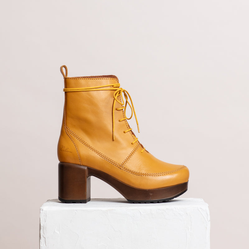 Yellow Lace-up leather clog boot on plinth