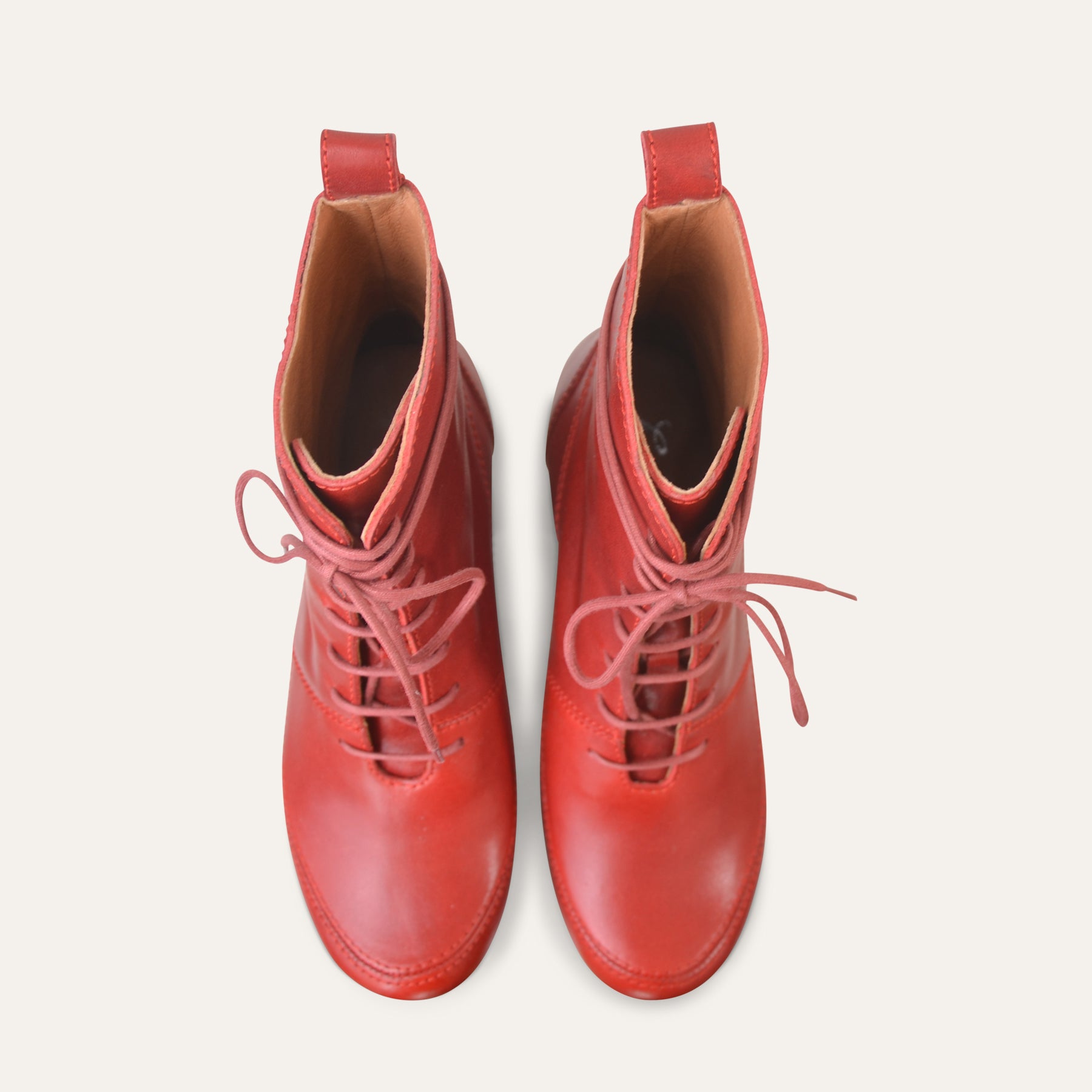 Pair of red leather boots on a white background
