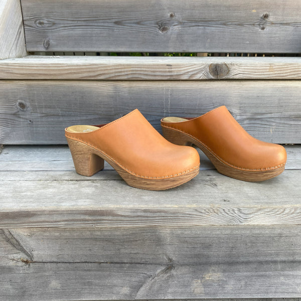 Classic brown leather clog on soft flexible high heel base on wooden stair