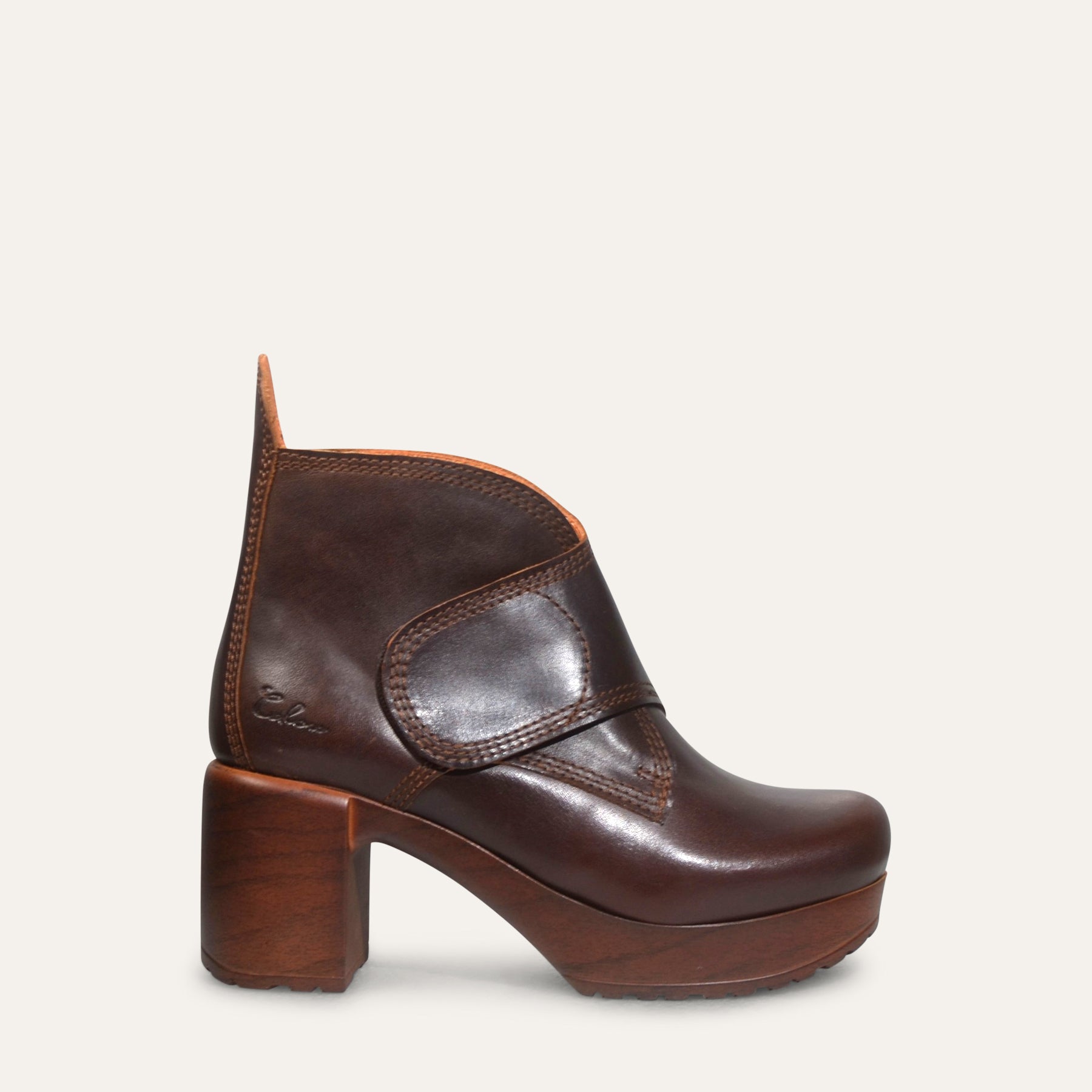 Brown leather ankle boot with a platform sole on a light gray background