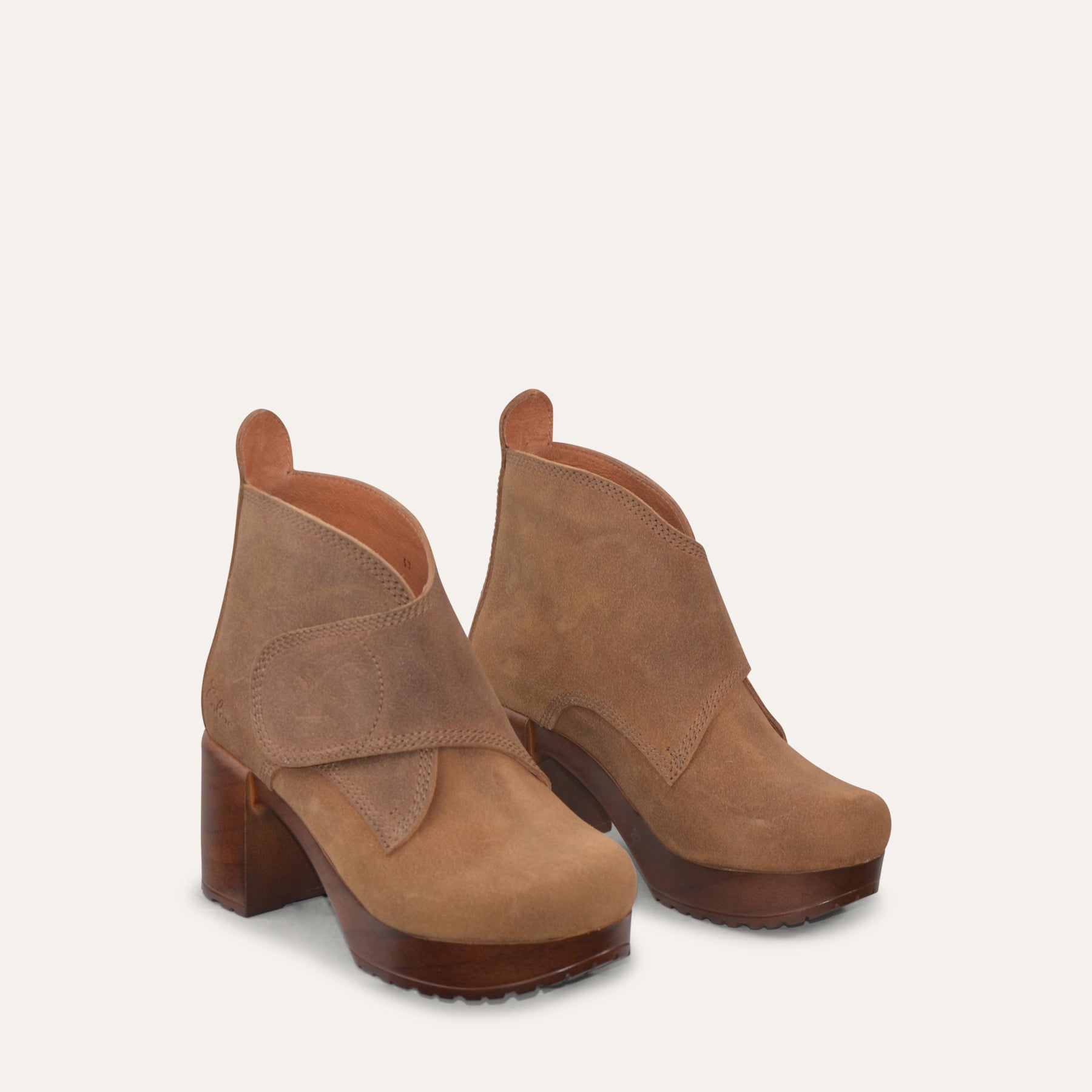 Pair of brown suede ankle boots on a light gray background