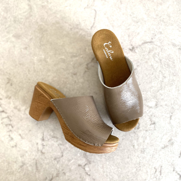 Slip on clogs with open toe, beige patent leather on stone slab